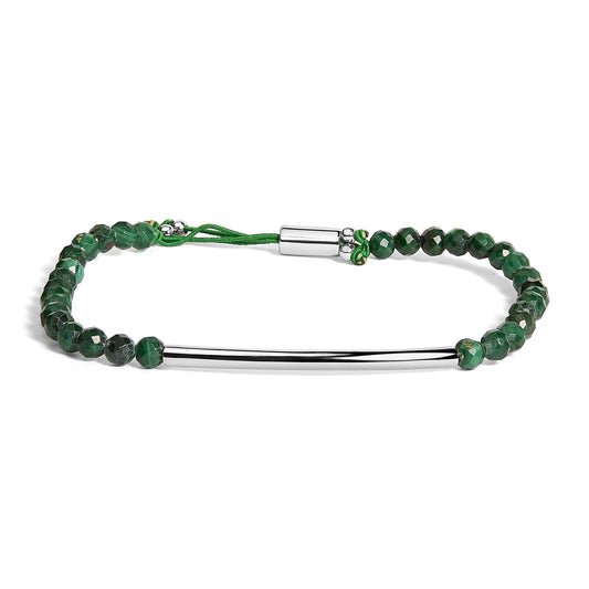 White metal bracelet with a curved bar and green faceted round beads strung on green cord, shown from a front angle on a white background.