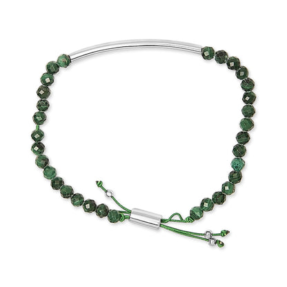 White metal bracelet with green faceted gemstones on a cord, shown from a top-down angle.