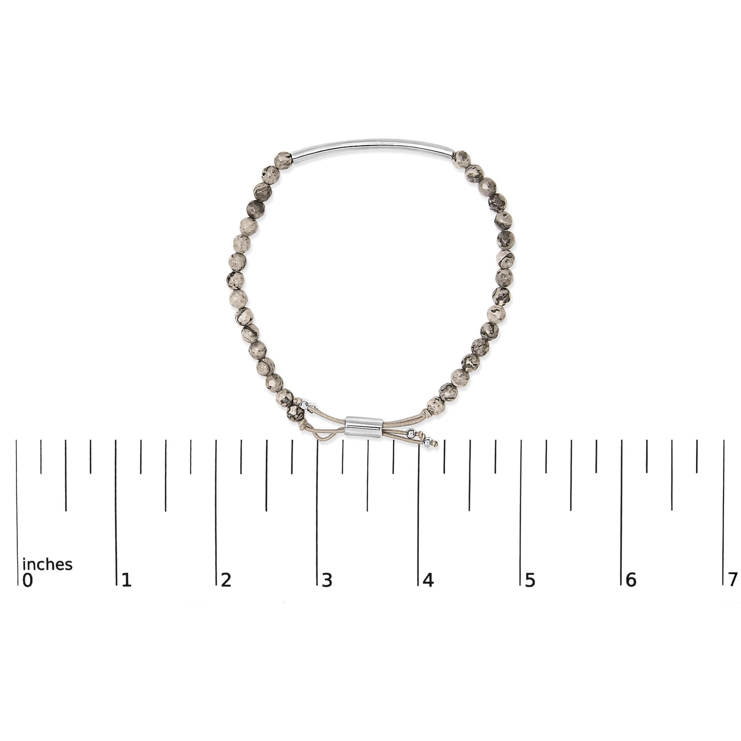 White metal bracelet with round speckled beads and adjustable closure shown on a flat measuring scale, top-down angle.