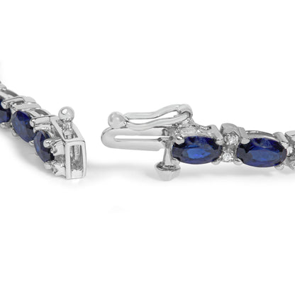 Close-up front angle of a white bracelet with oval blue gemstones and round white gemstones in prong settings, shown on a white background.