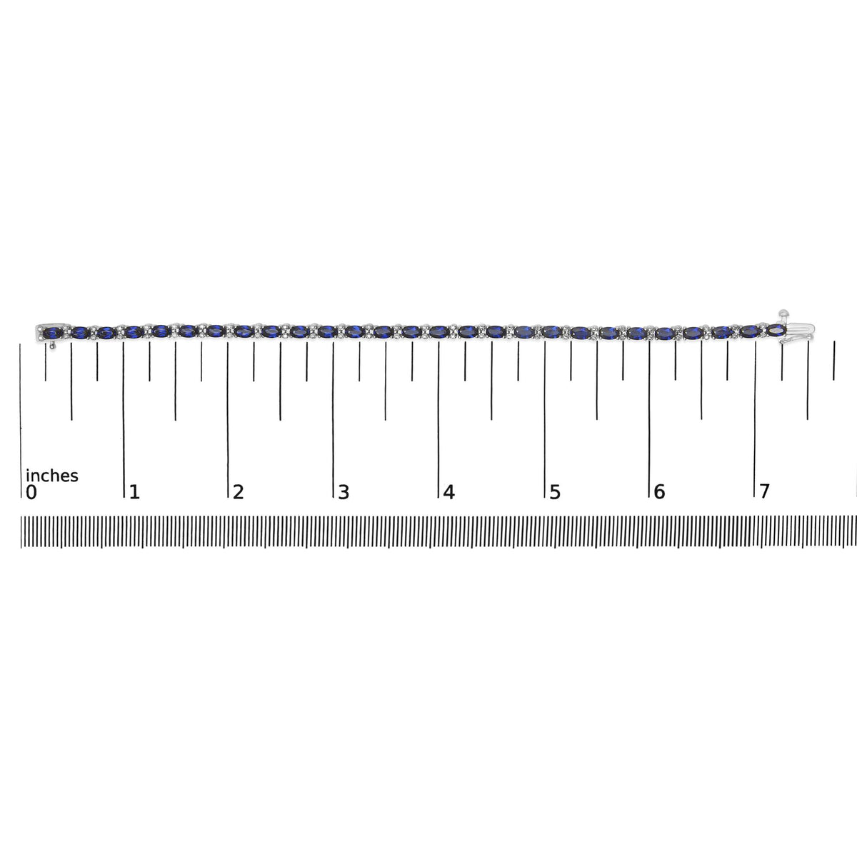 White metal bracelet with alternating oval blue gemstones and round white gemstones in prong settings, shown on a ruler scale, top-down angle.