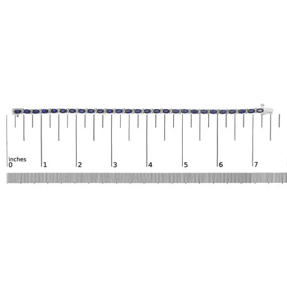 White metal bracelet with alternating oval blue gemstones and round white gemstones in prong settings, shown on a ruler scale, top-down angle.