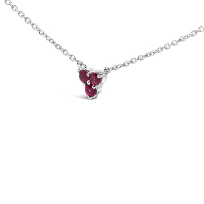 White metal necklace with a triangular cluster of round red gemstones in prong settings, shown in a close-up front angle.