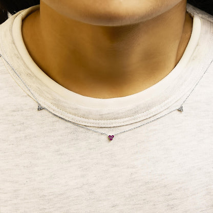 White metal necklace with a small pendant featuring round red and white gemstones in prong settings, shown worn on a model from the front angle.