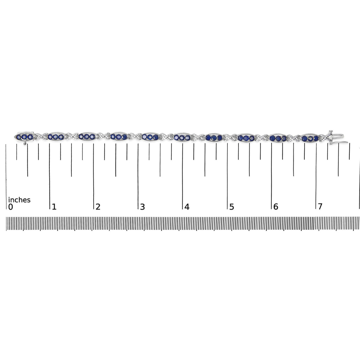 White bracelet with alternating oval sections containing blue gemstones and X-shaped links with white gemstones, shown on a scale, top-down view.