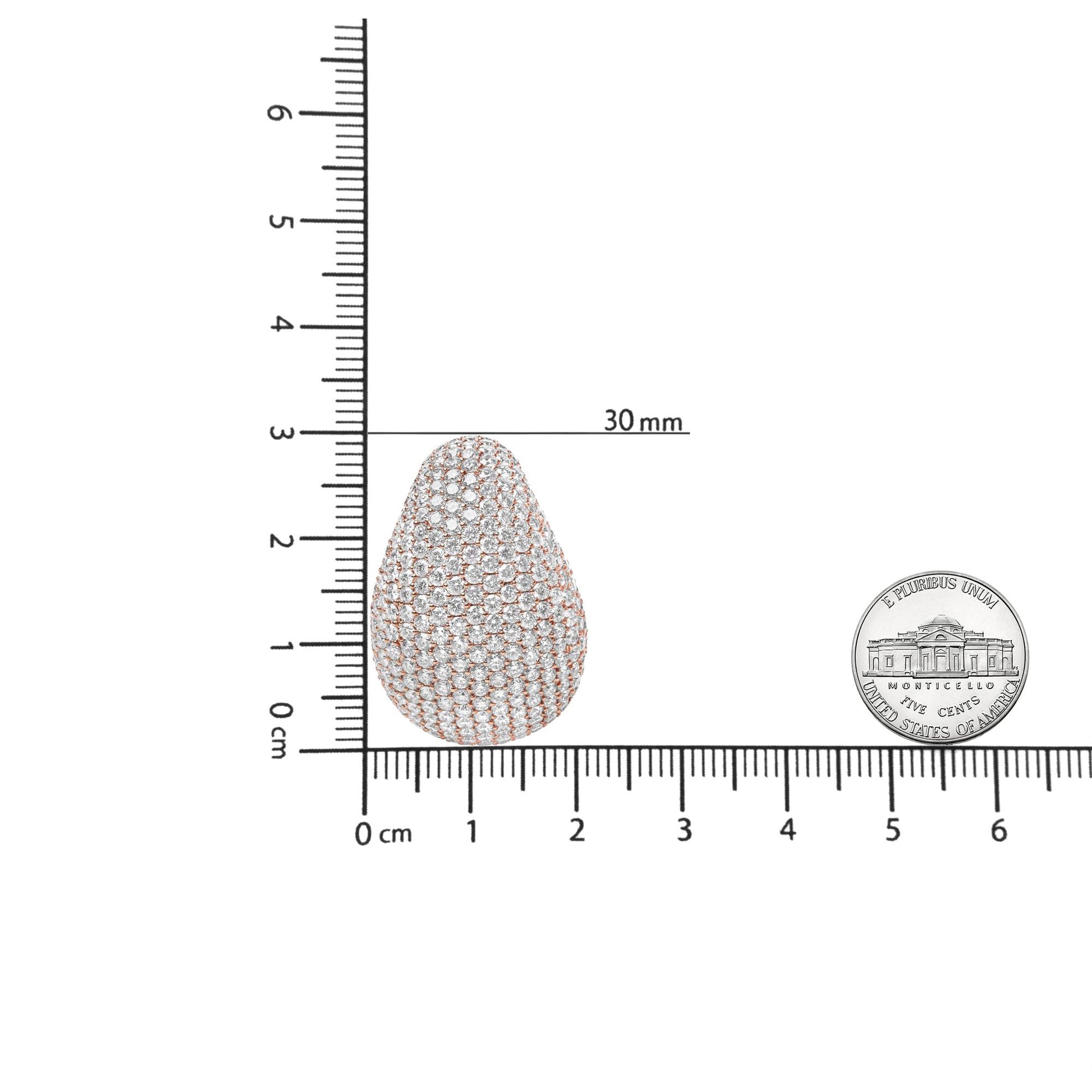 Close-up front view of a single rose-colored metal earring with round white gemstones in pave setting, shown on a ruler for size reference next to a US nickel coin.