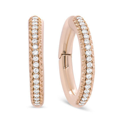 Close-up front and angled view of rose metal hoop earrings adorned with a row of round white gemstones in prong settings.