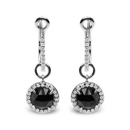 Front-facing shot of white metal drop earrings with a round black gemstone surrounded by small white gemstones, hanging from a white metal hoop also accented with white gemstones.