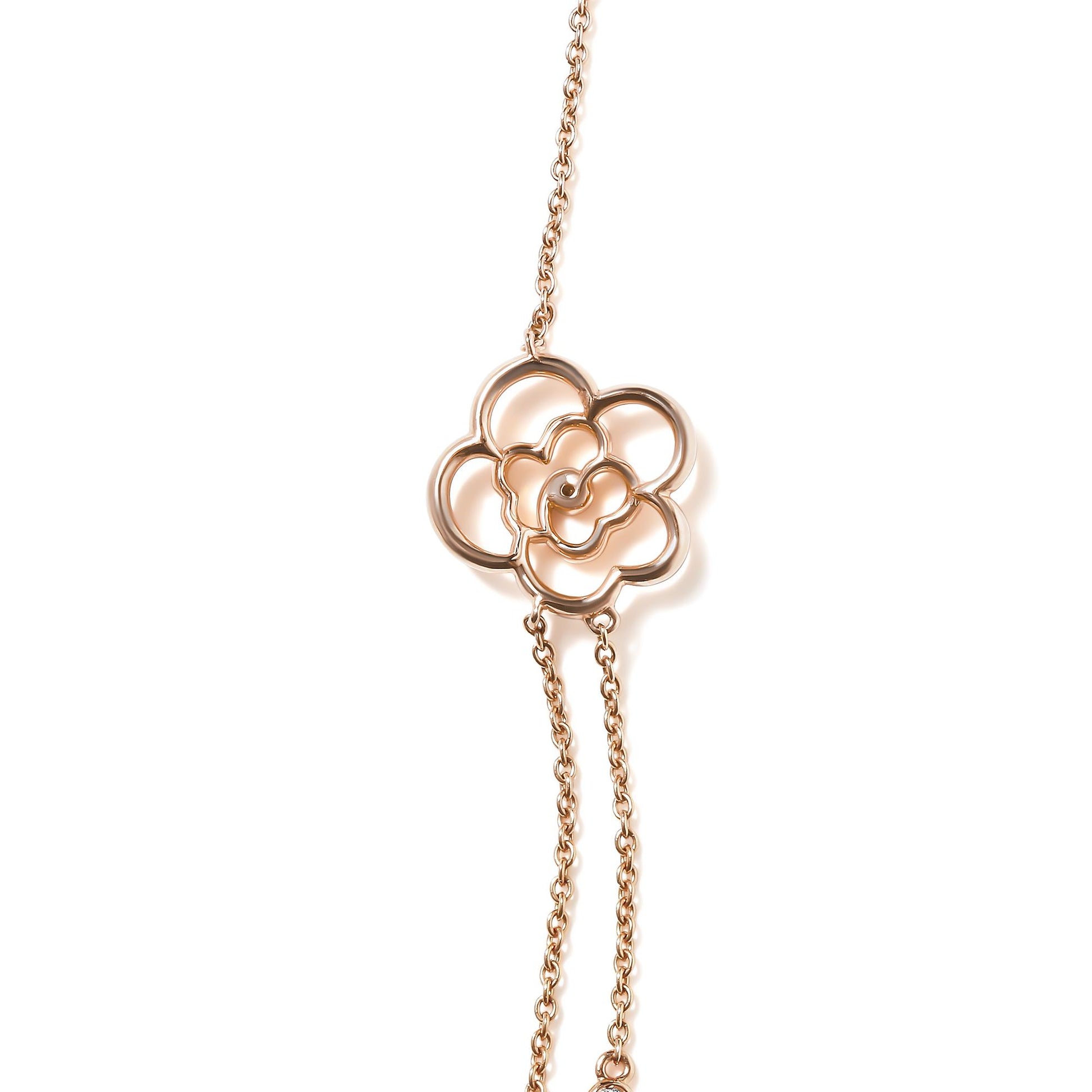 Close-up angled view of a rose-colored metal necklace with a flower-shaped pendant featuring a round white gemstone in a bezel setting, on a white background.