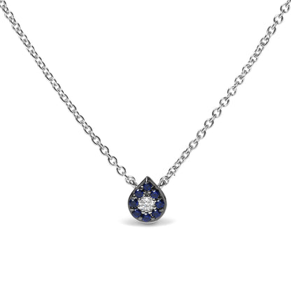 Front view of a white metal necklace with a teardrop-shaped pendant featuring a central round white gemstone surrounded by round blue gemstones in prong settings.