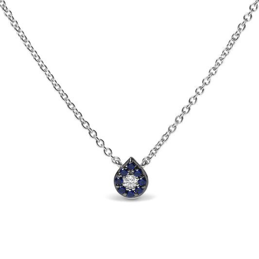 Front view of a white metal necklace with a teardrop-shaped pendant featuring a central round white gemstone surrounded by round blue gemstones in prong settings.