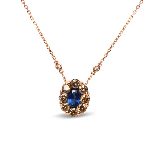 Front-facing shot of a rose metal necklace with an oval blue gemstone in bezel setting surrounded by round prong-set brown gemstones, and two round white bezel-set gemstones on the chain.