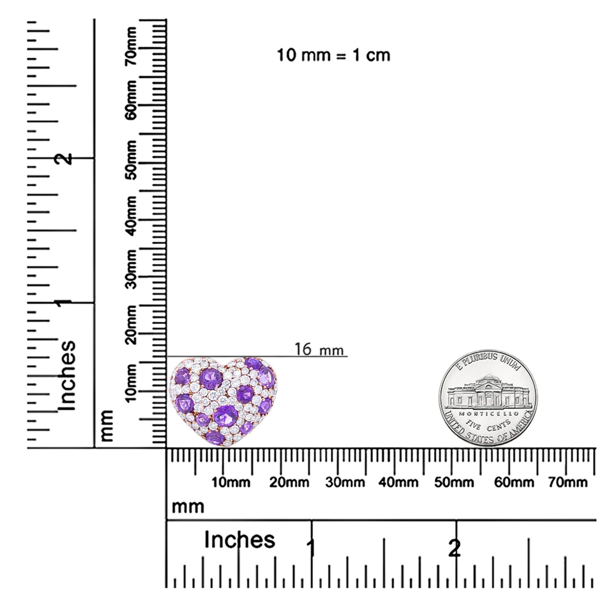 Heart-shaped rose-colored necklace pendant with purple and white gemstones in prong settings, shown on a ruler for size reference, front view.