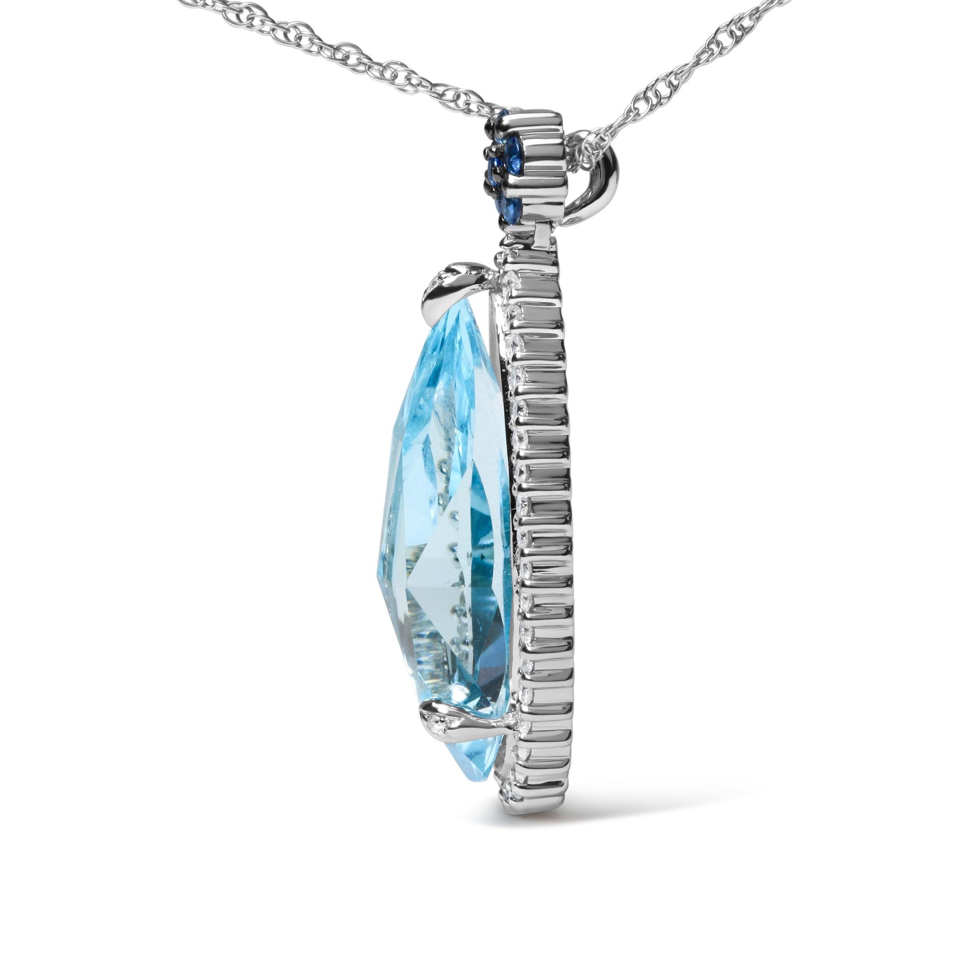 Side view of a white metal necklace pendant featuring a large pear-shaped blue gemstone in prong setting, surrounded by small round white gemstones and small round blue gemstones at the bail.