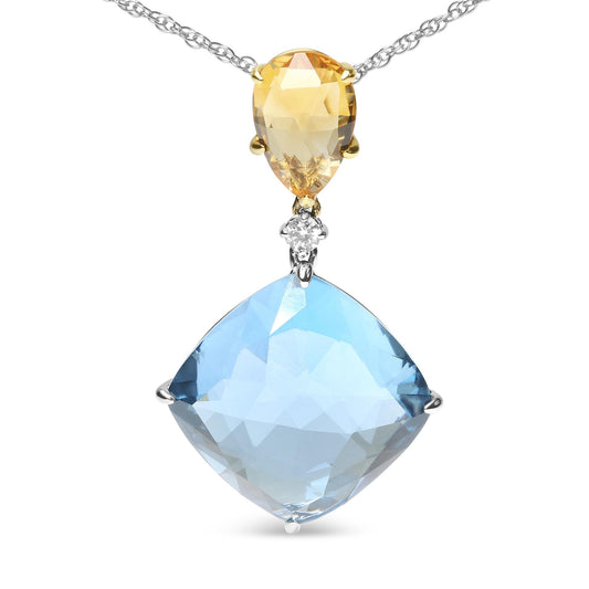 Close-up front view of a necklace pendant with a yellow pear-shaped gemstone set in yellow metal above a small round white gemstone, connected to a large cushion-shaped blue gemstone in white metal, hanging from a chain.