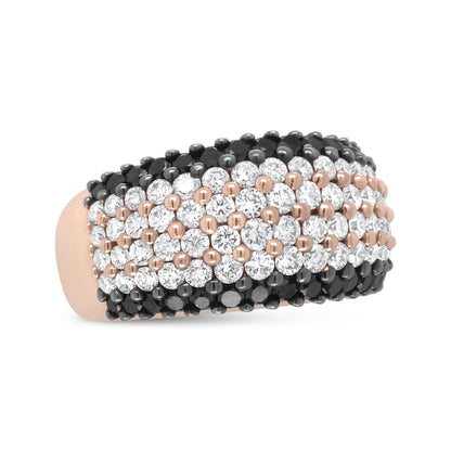 Close-up of a rose metal ring with multiple rows of round white and black gemstones set in prongs, shown at a slight angle.