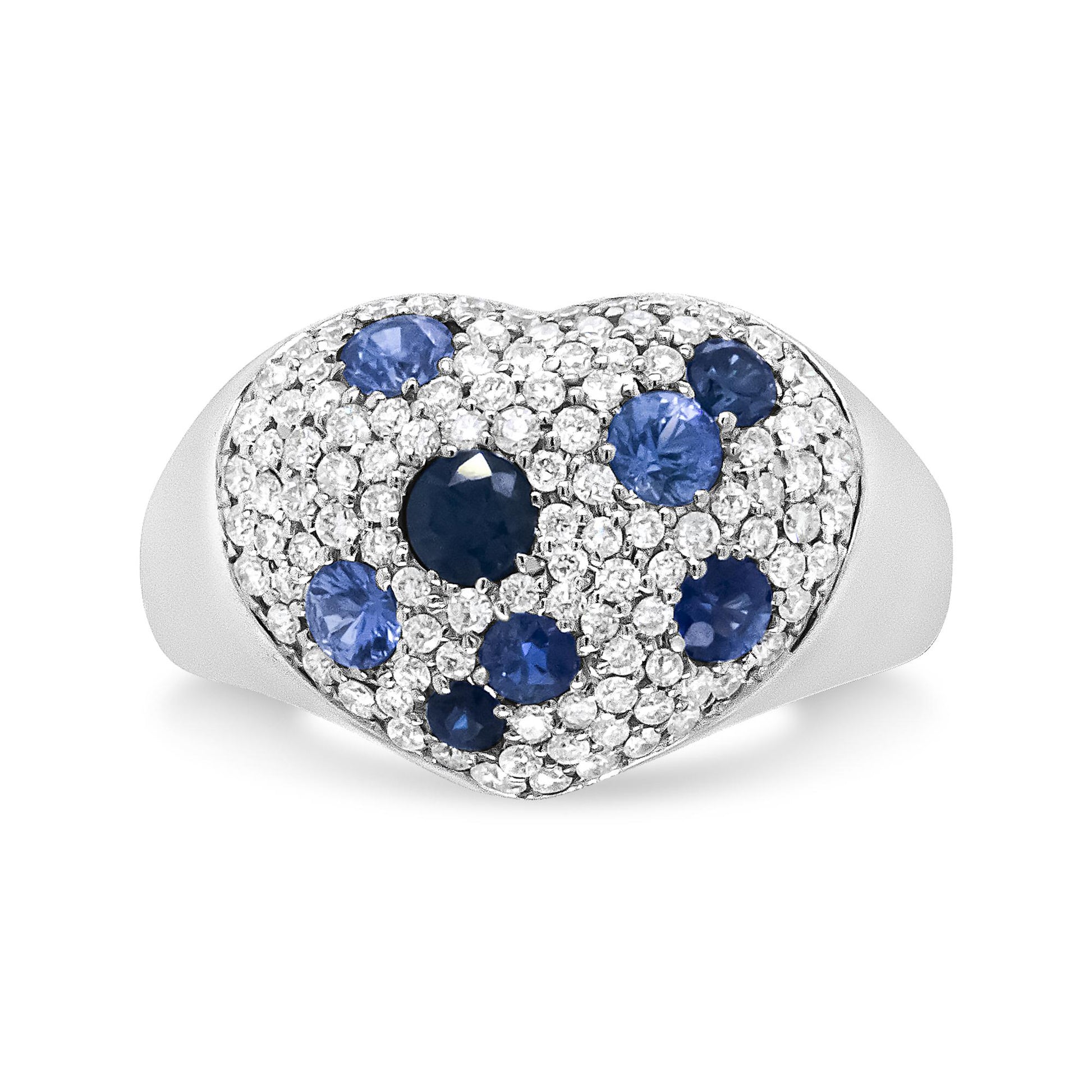 White metal heart-shaped ring viewed from the front, featuring round white gemstones in prong settings and multiple round blue gemstones in pave settings.