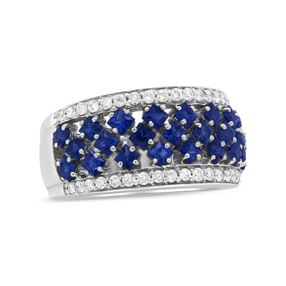 White metal ring with horizontal rows of prong-set blue princess-shaped gemstones in the center, bordered by rows of prong-set round white gemstones, shown at a slight angled side view.