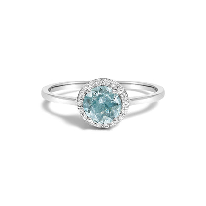 White metal ring with a round blue gemstone in a four-prong setting, surrounded by small round white gemstones in a shared prong setting, shown in a front-facing close-up angle on a white background.