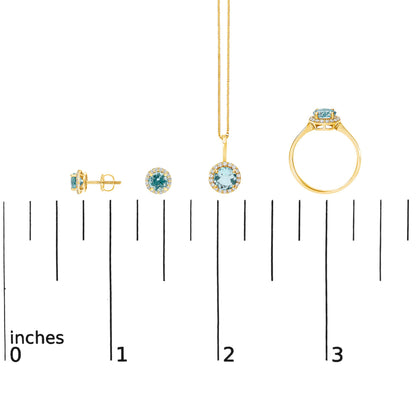 Jewelry set shown on a scale, including round blue gemstone stud earrings, a matching pendant necklace with surrounding white gemstones, and a ring with a round blue gemstone and surrounding white gemstones, all in yellow metal, displayed from side, front, and top angles.