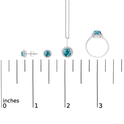 Jewelry set with stud earrings, a pendant necklace, and a ring, each featuring round blue gemstones surrounded by small white gemstones, shown on a ruler scale from a front and side angle.