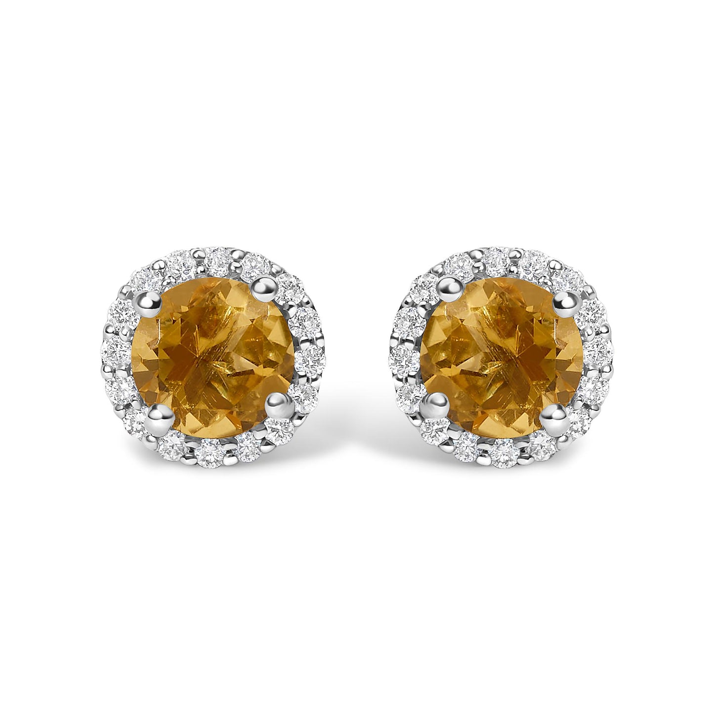 Close-up front view of a pair of stud earrings featuring round orange gemstones surrounded by a halo of round white gemstones, set in white metal.