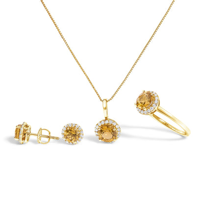 Set of jewelry including a pair of stud earrings, a pendant necklace, and a ring, all shown from a front angle on a white background. Each piece features a central round orange gemstone surrounded by small round white gemstones in a shared prong setting, mounted on yellow metal. The earrings are displayed with one facing forward and one in a side profile showing the screw-back.