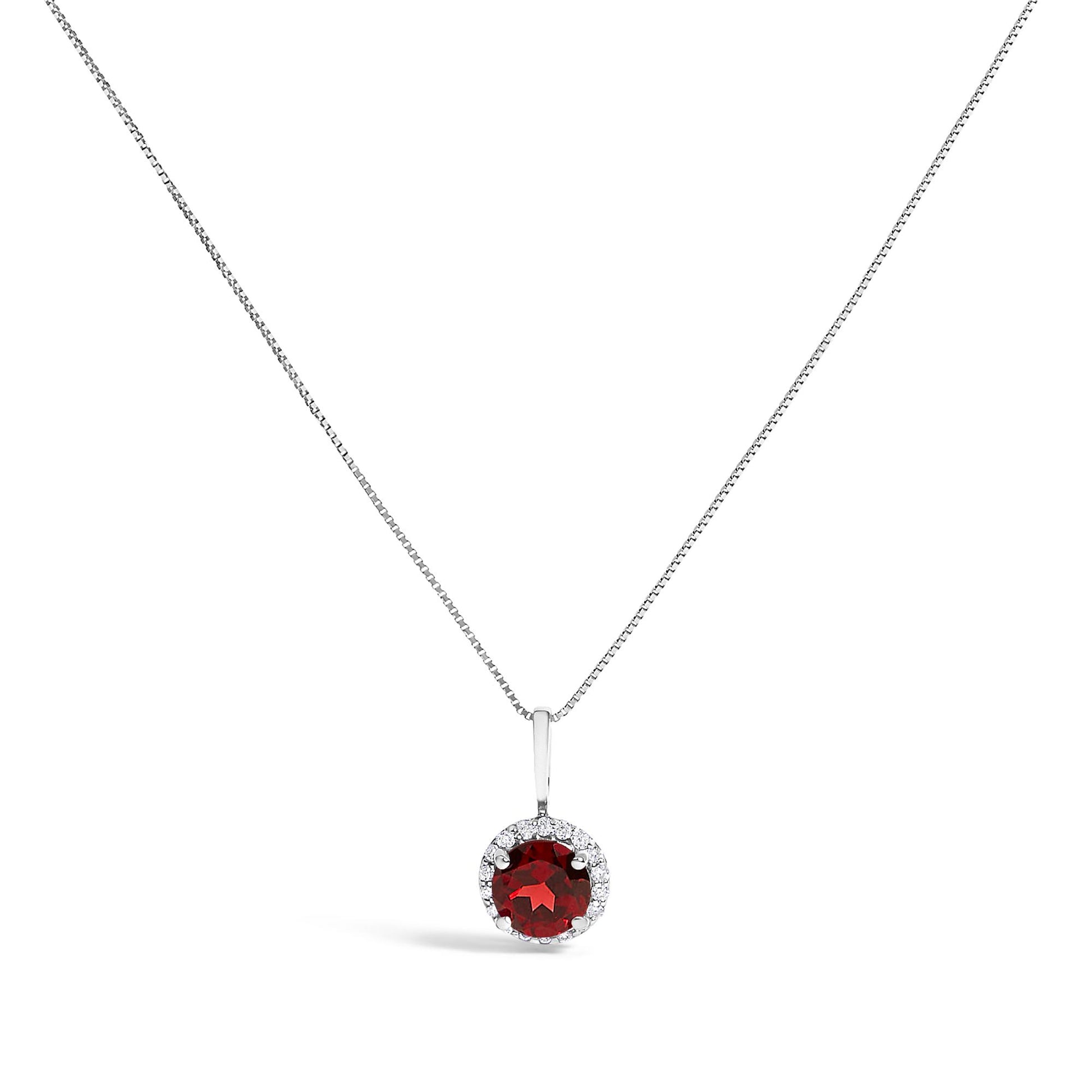 White metal necklace set shown from a front angle with a round red gemstone pendant surrounded by a halo of small white gemstones.