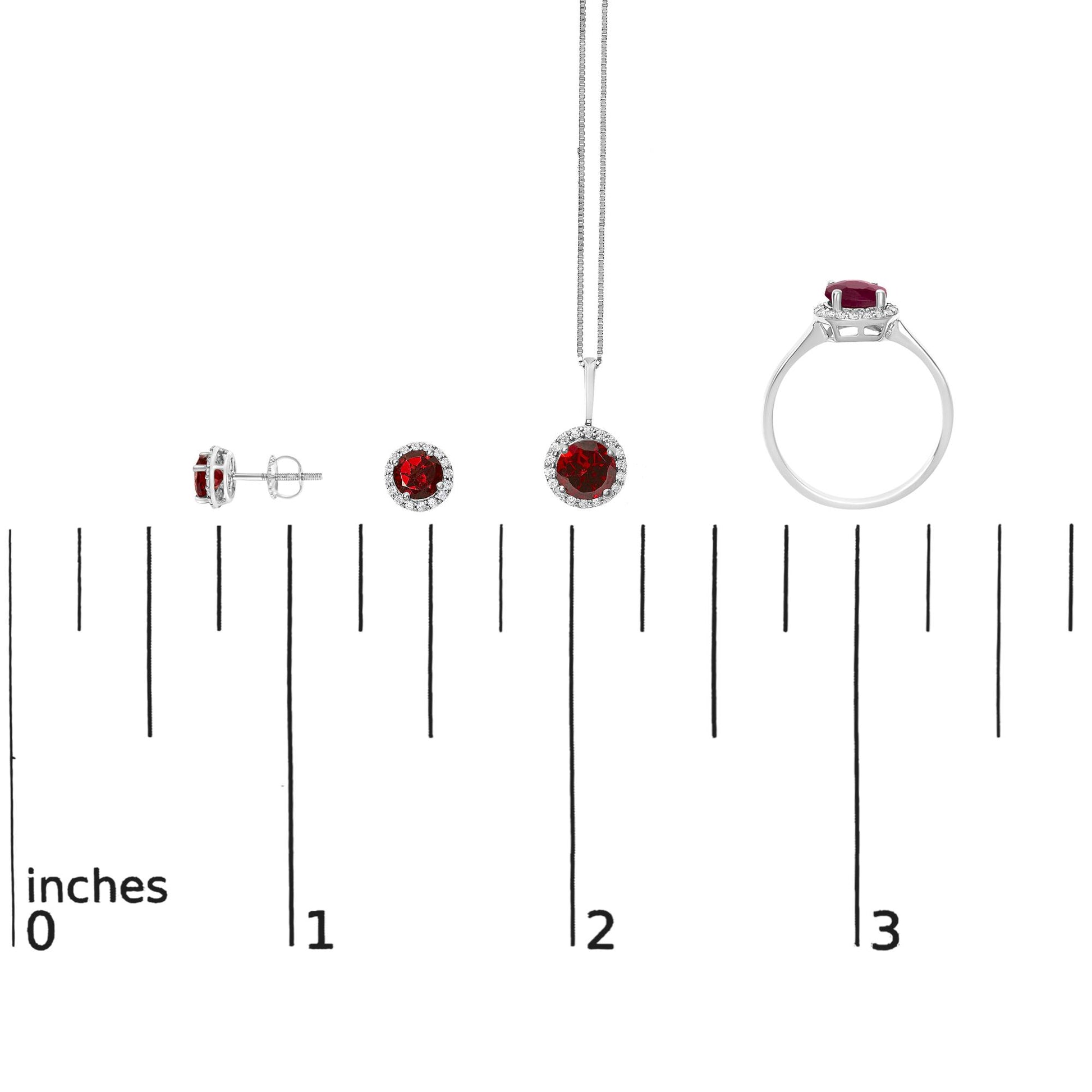 Set of white metal jewelry shown on a scale including a ring, a pendant necklace, and a pair of stud earrings, each featuring a round red gemstone surrounded by small round white gemstones, side and front views visible, shot from the front.