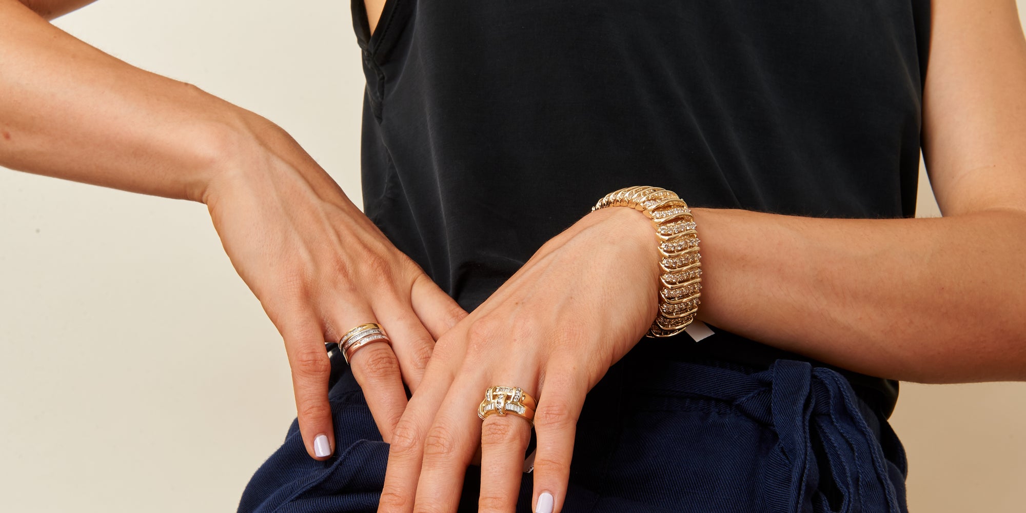 Haus of Brilliance model wearing gold and diamond bracelet and rings 