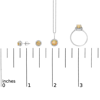 Jewelry set displayed on a white surface and shown on a scale, featuring round multi-color opal gemstones with surrounding round white gemstones set in white metal, including stud earrings, a pendant on a chain, and a ring, shot from the front with side and top angles.