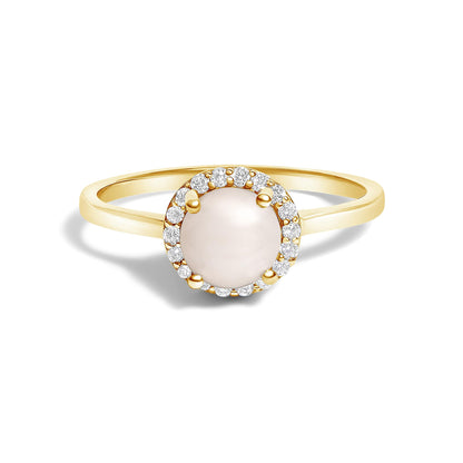 Close-up front view of a yellow metal ring with a round pale gemstone center surrounded by a halo of small white round gemstones in shared prong setting.