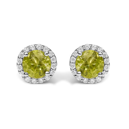 Close-up front view of a pair of round stud earrings with green round gemstones surrounded by a halo of small white round gemstones in shared prong settings.