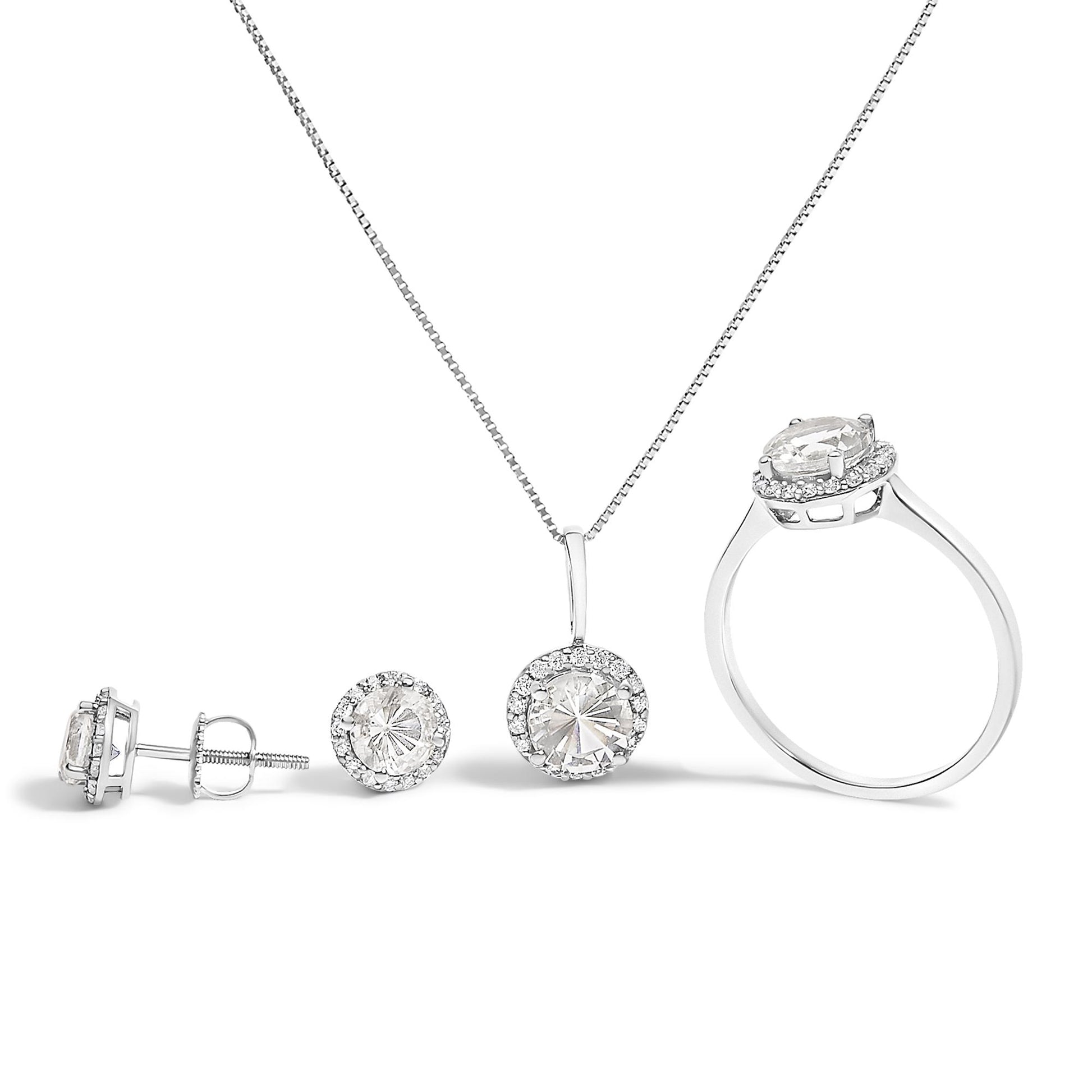 Image showing a white metal jewelry set consisting of a ring, a pendant necklace, and a pair of stud earrings. Each piece features a central round white gemstone surrounded by smaller round white gemstones in a shared prong setting. The set is displayed on a white background from a front-facing angle.